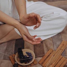 femme-appliquant-de-l'huile-essentielle-main-aromathérapie-avec-brûler-un-encens-bâton