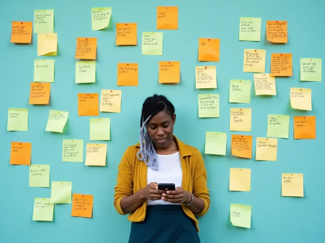 Personne débordée entourée d’alertes et de post-its, symbole de charge mentale liée au manque de documentation.